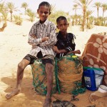 Two boys sitting on jerry cans in Mauritania