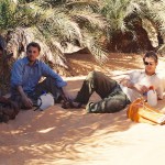 Ian Linington, Bill Edwards and Hakim in shade under palm trees Azougi Atar Mauritania